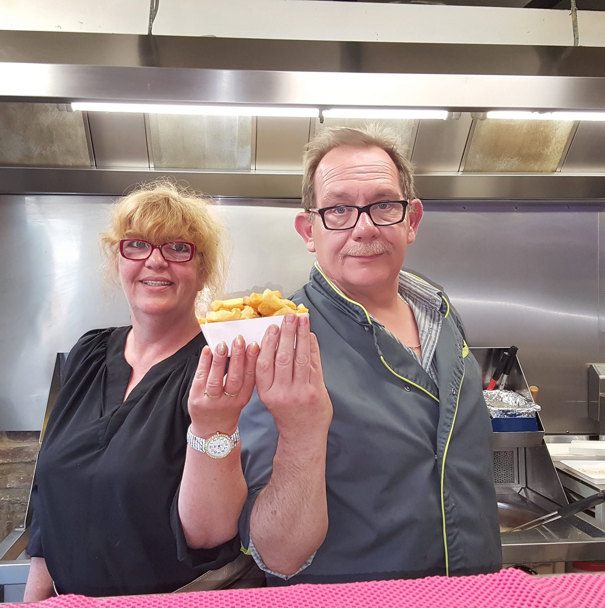 L'équipe de Family-frit en cuisine, un cornet de frites à la main